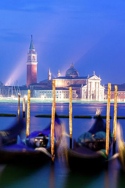 Romantic sky at dusk over gondolas moored with San Giorgio Maggiore Church and bell tower on background, Venice, Veneto, Italy