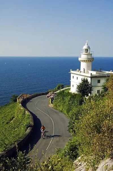San Sebastian Bay Clifftop Lighthouse with Cyclist Riding uphill