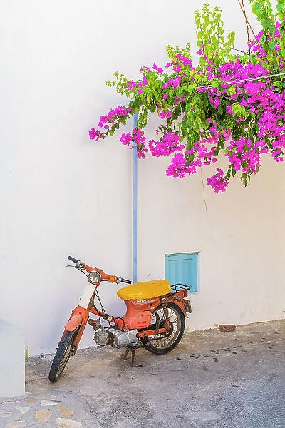 A scooter under bougainvillea, Halki, Chalki, Dodecanese Islands, Greece