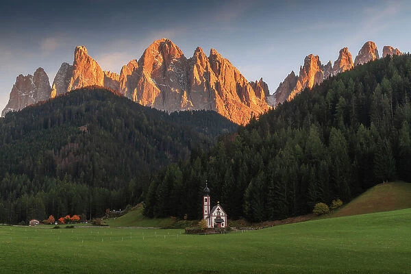 The small chapel of San Giovanni in Ranui with the Odle mountains. Dolomites, Italy