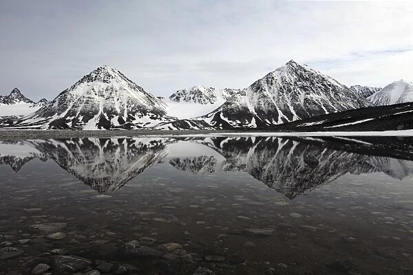 Spitsbergen, Svalbard, Norway. Mountains reflecting on a lagoon in northern spitsbergen