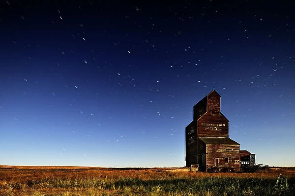 Star trails and moonlit grain elevator in ghost town Bents Saskatchewan, Canada
