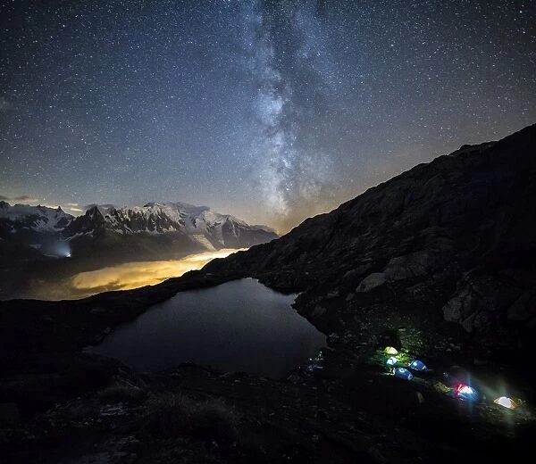 Stars and Milky Way illuminate the snowy peaks around Lac de Cheserys, Chamonix, Haute Savoie