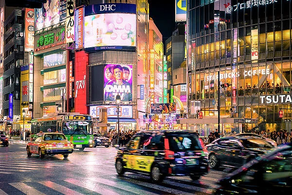 Summer nightlife in Shibuya Tokyo, with taxis, illuminated signs and people crowding streets and caf√®