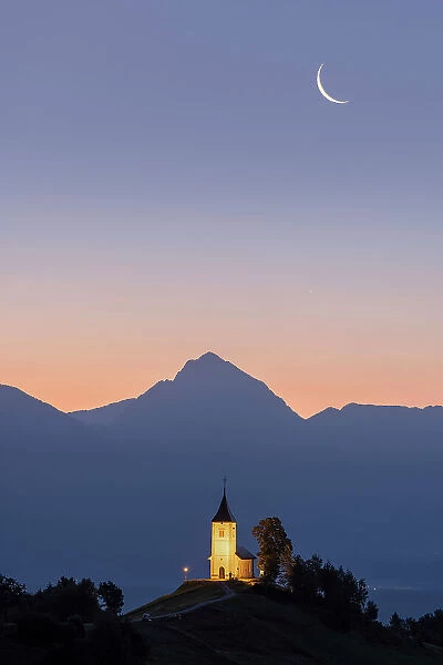Summer sunrise and moonrise over Church of St. Primoz, Jamnik, Slovenia