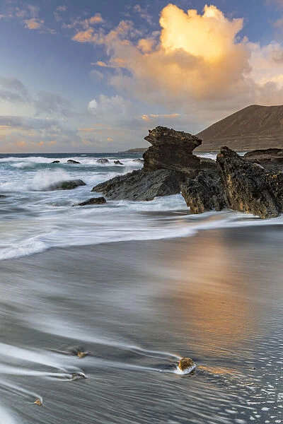 Sunset clouds over the rough sea at Playa de la Solapa beach, Pajara, Fuerteventura