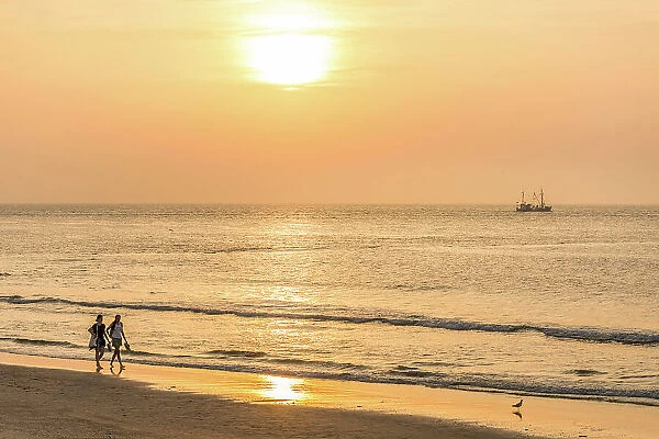 Sunset walkers on the northern beach of Norderney, East Frisian Islands, East Frisia, Lower Saxony, Germany