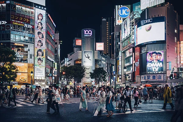 Typical view of Tokyo Shibuya crossing from below. Pedestrian crossing full of people walking in a summer night, Japan