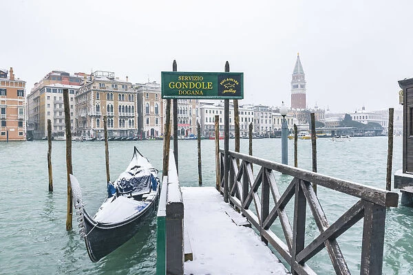 Venice, Veneto, Italy. Gondolas on the waterfront with snow in Dorsoduro