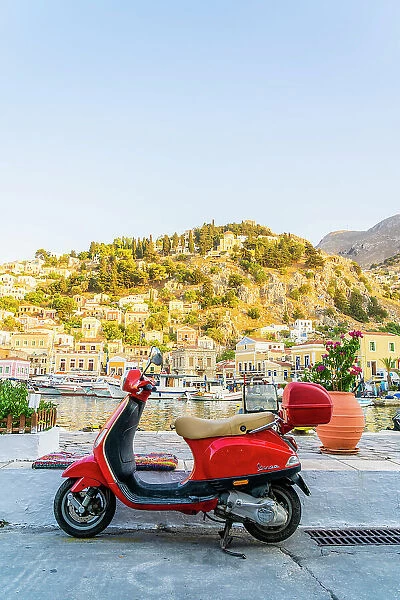 A vespa scooter by the colourful harbour in Symi, Dodecanese Islands, Greece