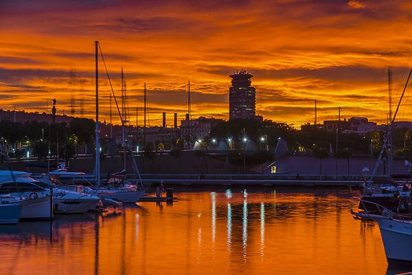 View of Port Vell harbor at sunset with dramatic red sky, Barcelona, Catalonia, Spain