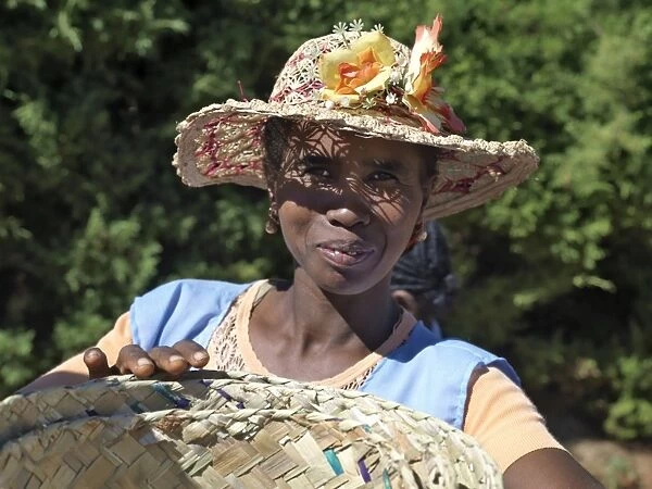 A woman wearing a decorated Malagasy hat sells baskets in Ambalavao market