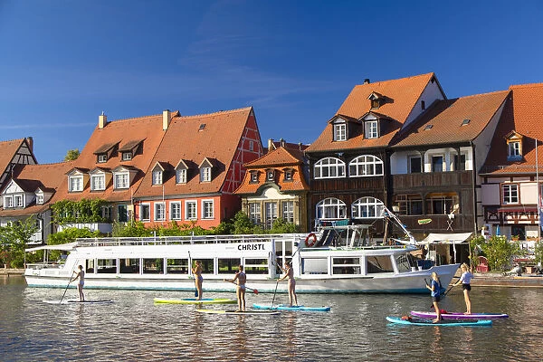 Women paddleboarding past houses of Klein Venedig (Little Venice), Bamberg (UNESCO