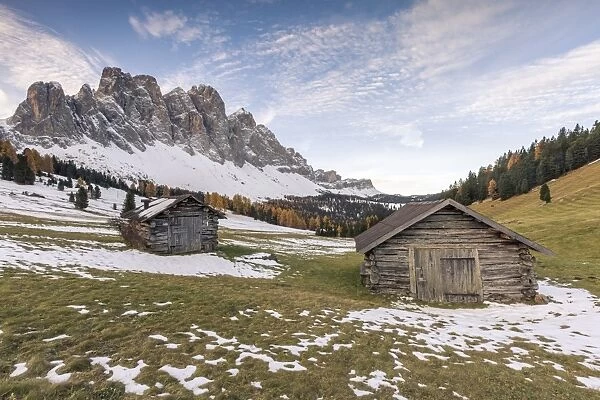 Two wooden lodges and Odle Dolomites. Malga Gampen, Funes, Bolzano, Trentino Alto Adige - Sudtirol