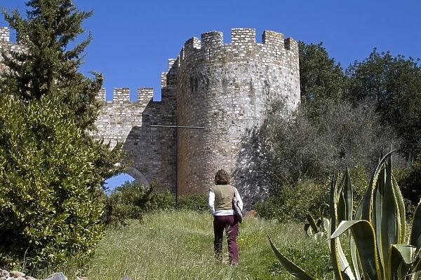 A young tourist takes a path up to the castle in the