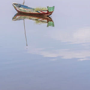 Africa, Senegal, Sine-Saloum-Delta. Fishing boat reflecting in the water