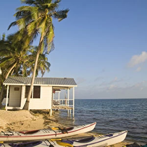 Belize, Tobaco Caye, Kayaks on beach by hotel cabanas