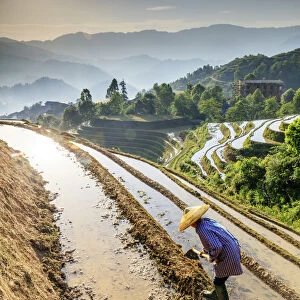 China, Guangxi Province, Longsheng, a farmer wearing a traditional hat working