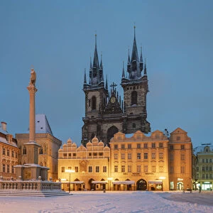 Church of our lady before Tyn at snow-covered Old Town Square at twilight in winter