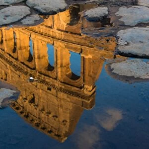 Colosseum or Coliseum reflected in a puddle at sunset, Rome, Lazio, Italy