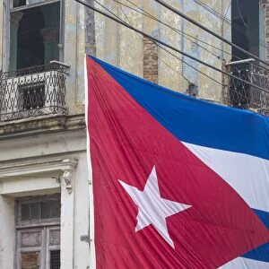 Cuba, Huge Cuban flag hanging across buildings in a street in Santa Clara, after