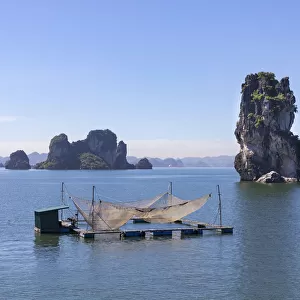Fishing nets on a raft in front of karst rocks, Halong Bay, Quang Ninh Province
