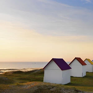 France, Normandy, Gouville Sur Mer, colourful beach huts at dusk