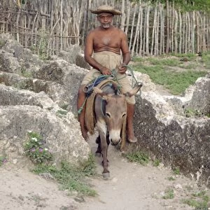 An inhabitant of Pate village rides his donkey through