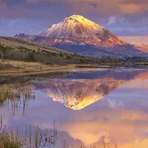 Ireland, Co. Donegal, Snow capped Errigal mountain reflected in Clady river at dusk