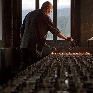 A man lighting candles in a temple in Bhutan