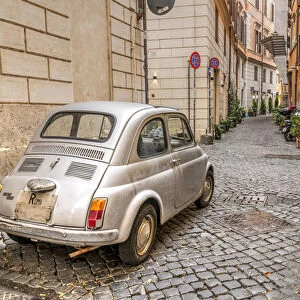 Old classic Fiat 500 car parked in a cobbled street of Rome, Lazio, Italy