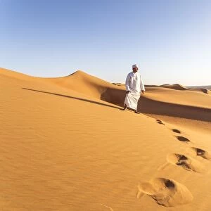 Oman, Wahiba Sands. Bedouin on the sand dunes at sunset (MR)