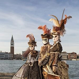 Three people in costume at Carnival time, San Giorgio Maggiore, Venice, Veneto, Italy