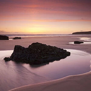 Rockpools on the sandy shores of Bedruthan Steps at sunset Cornwall, England. Spring