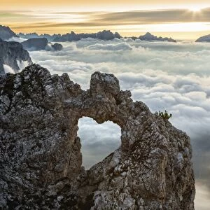 A rocks heart, on a clouds sea, between rock walls. (Dolomites, Italy)