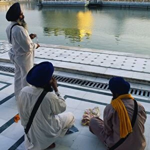 Silk pilgrims pause beside the Amrit Sarovar