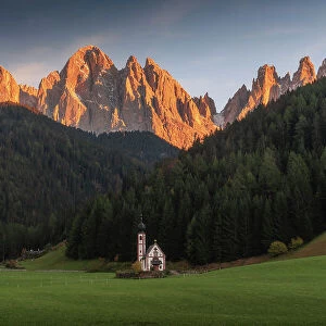 The small chapel of San Giovanni in Ranui with the Odle mountains. Dolomites, Italy