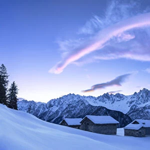 Stunning clouds above huts at sunrise. Soglio, Bregaglia Valley, Canton of Grisons