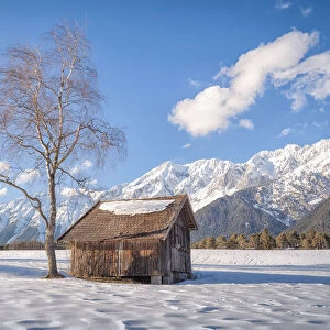 A typical wooden cabin in the snowy fields of Wildermieming, Mieming, Sonnenplateau