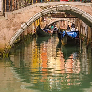 Venice, Veneto, Italy. Bridges and gondolas moored in a canal