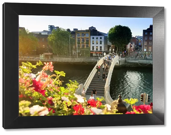 Europe, Dublin, Ireland, tourists crossing the famous Halfpenny bridge on the Liffey