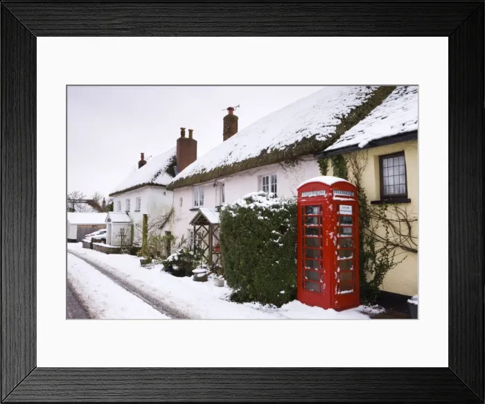 Framed Print : Snow covered cottages and traditional phone box in the village of Morchard Bishop Framed Print : Snow covered cottages and traditional phone box in the village of Morchard Bishop