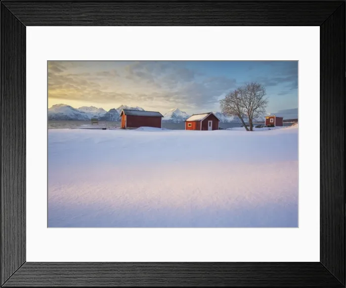 Framed Print : The orange sky at sunset frame the frozen sea and typical Rorbu immersed in the snow Framed Print : The orange sky at sunset frame the frozen sea and typical Rorbu immersed in the snow