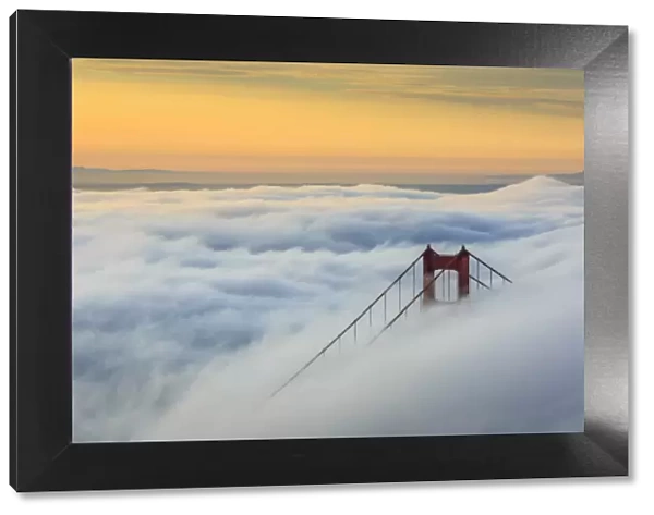 Golden Gate Bridge emerging from the morning fog at sunrise. San Francisco, Marin County