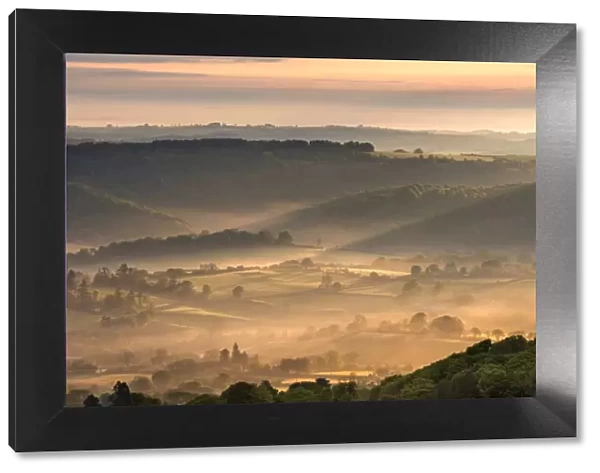 Mist covered rolling countryside at dawn, Dartmoor National Park, Devon, England