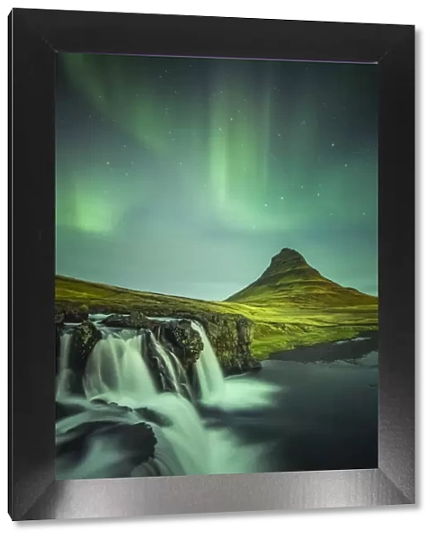 Long exposure landscape with waterfalls and aurora borealis above Kirkjufell Mountain