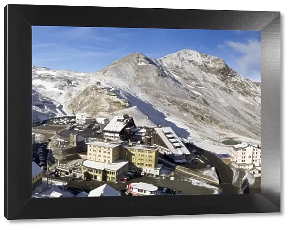 Panoramic view from the Stelvio pass, with a little of snow, and houses and hotels on the Pass