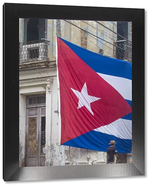 Cuba, Huge Cuban flag hanging across buildings in a street in Santa Clara, after