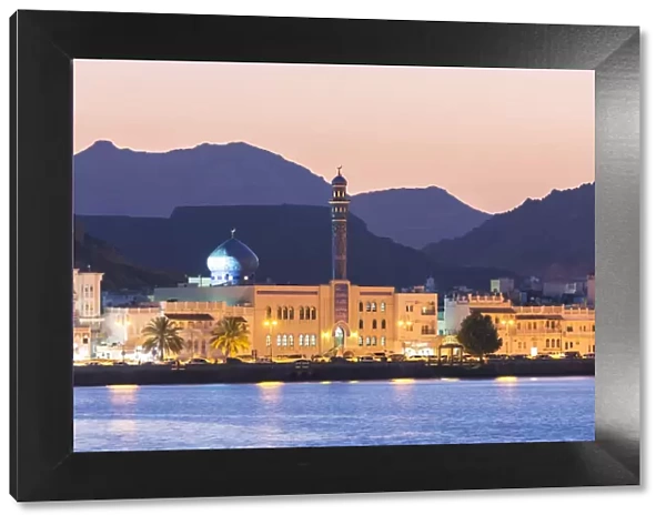 Oman, Muscat. Mutrah harbour and old town at dusk