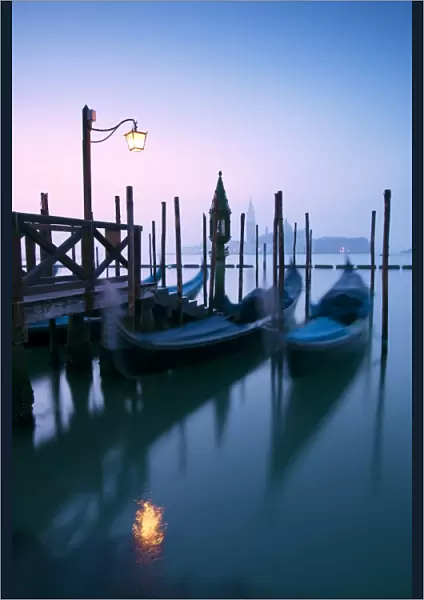 Italy, Venice. Gondolas moored on Riva degli Schiavoni at sunrise